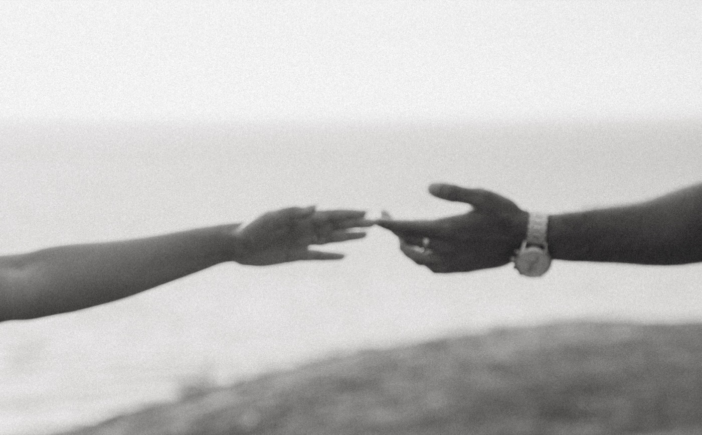 Rakshana and Nihal reaching for each other’s hands.